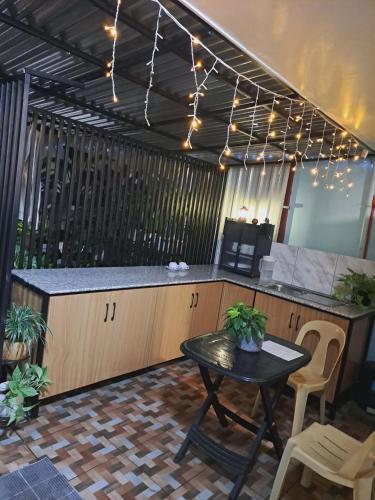 a bar with a table and chairs and lights at Dalinda's Homestay in Puerto Princesa City