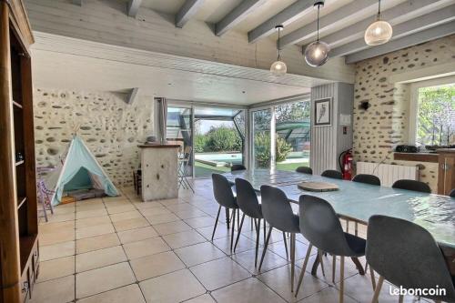 une salle à manger avec une grande table et des chaises dans l'établissement Le Clos Fleuri, à Pontiacq-Viellepinte