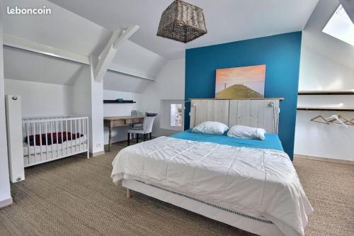 une chambre avec un lit avec un mur bleu dans l'établissement Le Clos Fleuri, à Pontiacq-Viellepinte