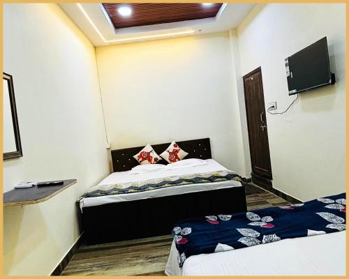 a room with two beds and a tv in it at Hotel Shree- Nidhi Premium comfort # Stay Near Mahakaleshwar Jyotirlinga # Railway Station # Free Wi-Fi And Parking Service - Best Hotel In Ujjain in Ujjain