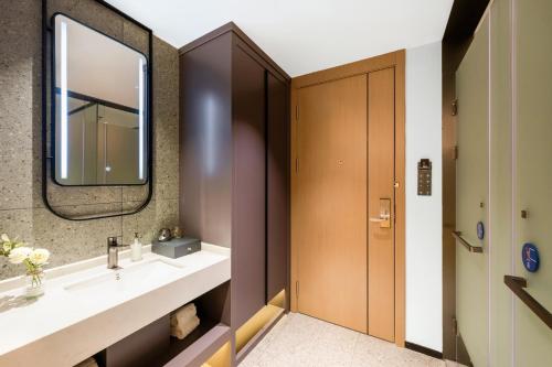 a bathroom with a sink and a mirror at Poltton Century Hotel - Zhongshan Dayong Redwood Culture Expo City in Zhongshan
