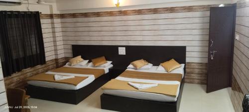 2 camas en una habitación con pared en Yammuna Vihaar Tourist Home, en Kollūru