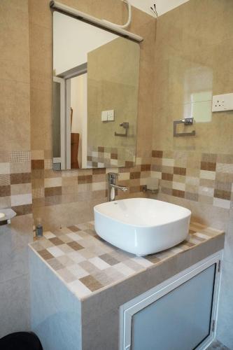 a bathroom with a large white sink and a mirror at Grand Castellea Resort in Wattegama