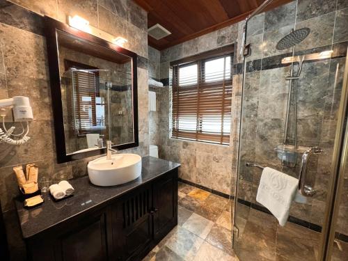a bathroom with a sink and a shower at TTC Hotel - Hoi An in Hoi An