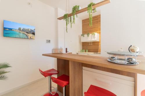 a kitchen with a counter and red stools at Dimore di Matilde - Alta Marea in Gallipoli