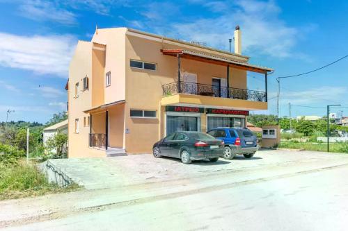 Un edificio con dos coches aparcados delante. en Casa Verde Blu, en Perivólion