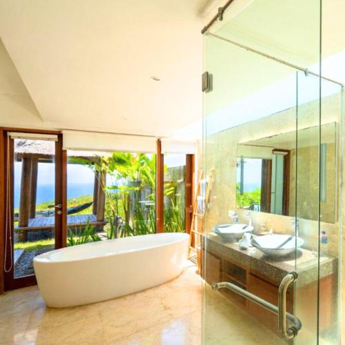 a bathroom with two sinks and a large tub at Vivo Villas - Villa Vivo in Uluwatu