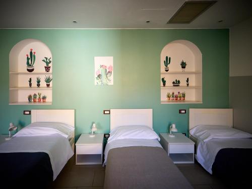 a room with two beds and shelves with cactuses at L'Archetto in Cremona
