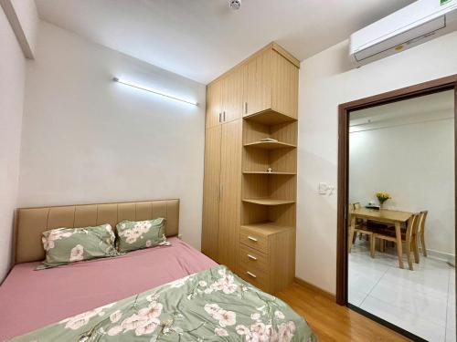 Phú MỹOsimi Phu My Apartment - 1 bedroom的卧室里有一张床、一面镜子和一张桌子