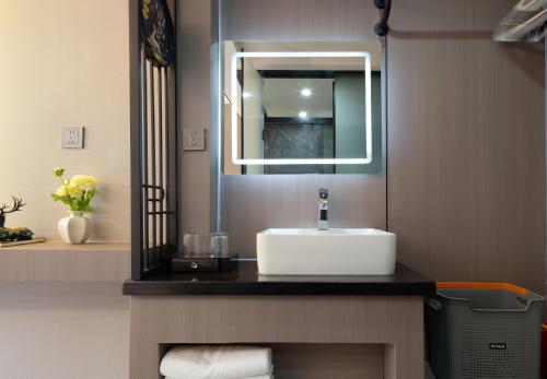 un baño con lavabo y espejo en Yiyun Residence, en Hanqiyu