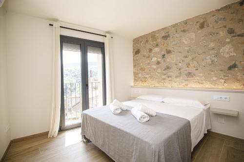 贝萨卢Apartamento en el Pont Vell的一间卧室，床上有一张带毛巾的床