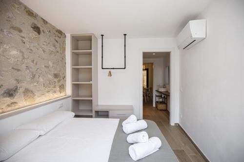 贝萨卢Apartamento en el Pont Vell的客厅配有白色家具和石墙