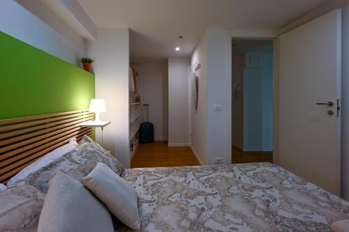 a bedroom with a large bed with a green wall at La Tana di Alice in Muggia