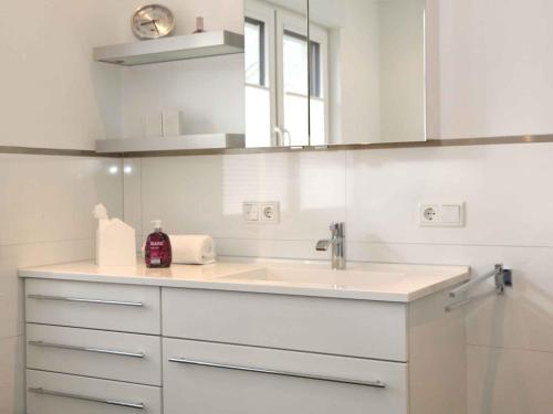 a white bathroom with a sink and a mirror at Fewo Wrede am Sauerland-Radring in Wenholthausen