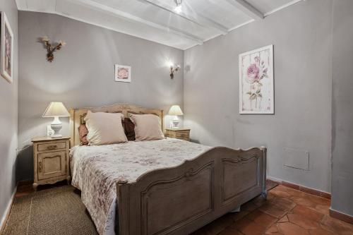 Le Patio في Laouque: غرفة نوم بها سرير كبير وطاولتين جانبيتين