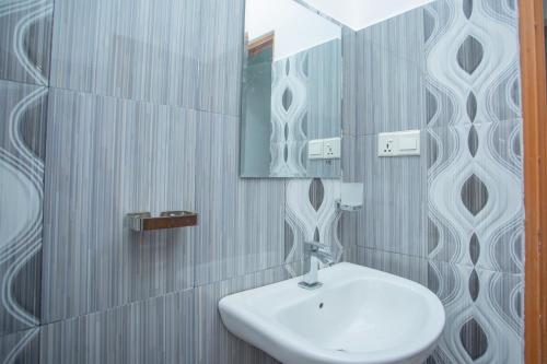 ein Badezimmer mit einem weißen Waschbecken und einem Spiegel in der Unterkunft Villa Aliya in Habaraduwa Central