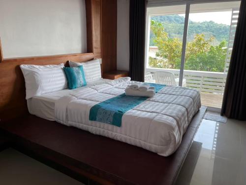 a large bed in a bedroom with a large window at Phulanta Resort in Ko Lanta Yai