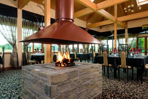 a fireplace in the dining room of a restaurant at Landal Piperdam in Dundee