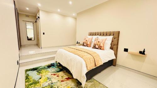 een slaapkamer met een groot bed en een tapijt bij Melodia V in Durban
