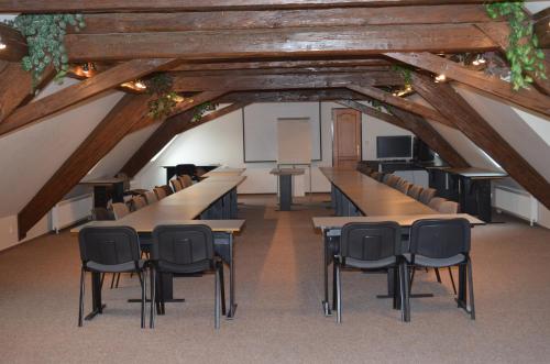 a classroom with tables and chairs in a room at Hotel Na Statku in Nepřevázka