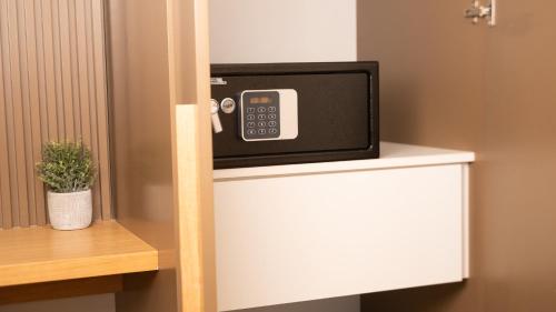 un micro-ondes posé sur une étagère dans une pièce dans l'établissement Guest House Aura - Lumys Fiumicino, à Isola Sacra