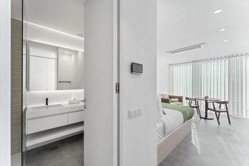 una camera da letto con un letto, un lavandino e uno specchio di GuestReady - Central Premium Studio - Aveiro ad Aveiro
