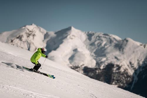 a person is skiing down a snow covered mountain at Posthof - Alpine Living Apartments in Campo di Trens