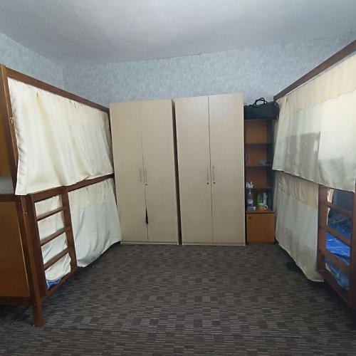 un dormitorio con armarios blancos y una escalera en él en Mary&George, en Chişinău