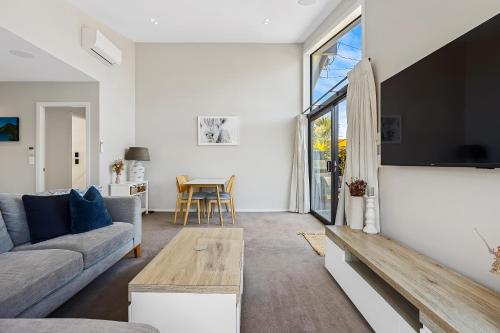 a living room with a couch and a table at Modern Two-Bedroom Home in Merivale in Christchurch