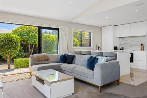 a living room with a couch and a kitchen at Modern Two-Bedroom Home in Merivale in Christchurch