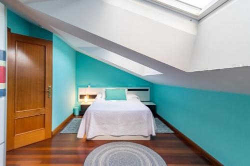 una camera da letto con un letto e una parete blu di Espectacular dúplex en Cartes a Cartes