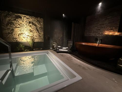 a bathroom with a bath tub and a sink at ALPENGARTEN EIGENTHAL - Private Wellness Retreat in Eigenthal