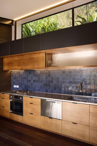 a kitchen with wooden cabinets and a sink and a window at Minden Retreat in Te Puna