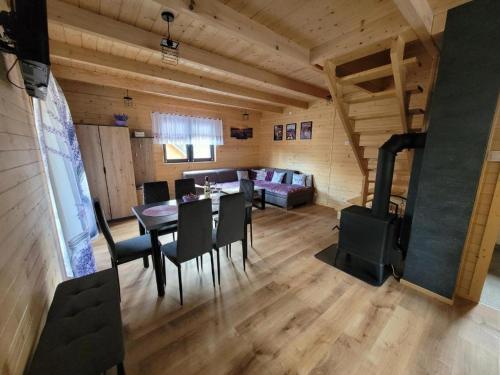 a dining room and living room with a table and chairs at Agroturystyka Lawendowa Dolinka Domki Beskid Niski in Chyrowa