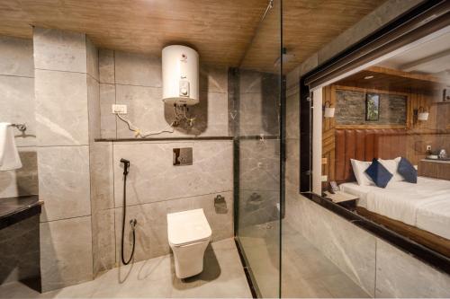 a bathroom with a shower and a toilet in a room at Hotel Monal in Manāli