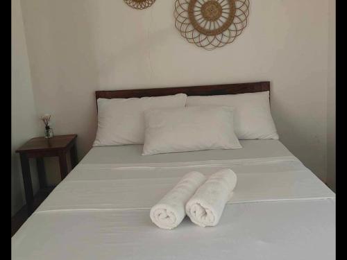 two towels on a bed in a room at Two Season Tourist Inn in San Vicente