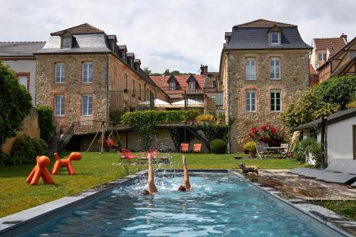 zwei Personen schwimmen in einem Pool im Hinterhof in der Unterkunft Maison d'hôtes La Chevalée in Hautvillers