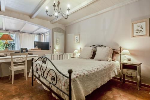 L'Arbousier في Laouque: غرفة نوم بها سرير وطاولة ومكتب