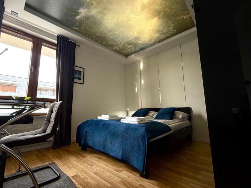 a bedroom with a bed with a painting on the ceiling at Jacuzzi & Parking Piernikowy Spa Apartment by Rentoom in Toruń