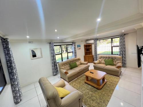 Una sala de estar con sofás y una mesa de café. en La Vue, en Port Shepstone