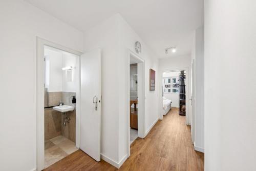 a white apartment with a bathroom and a bedroom at Casa Tantris zentral und modern mitten in Gmund in Gmund am Tegernsee