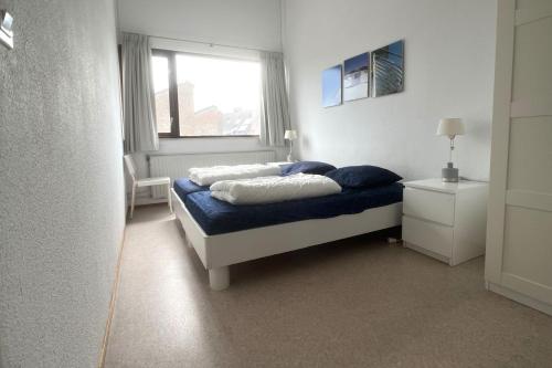 ein Schlafzimmer mit einem Bett mit zwei Kissen und einem Fenster in der Unterkunft De Vuurtoren, Lijsterstraat 12 in Tiel