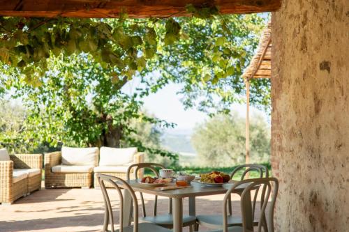 uma mesa com uma tigela de fruta no pátio em Podere Montale Il Borgo em Seggiano
