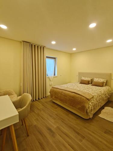 a bedroom with a large bed and a chair at Refugio do Surf Cortegaça in Cortegaça