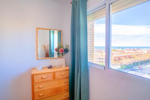 - une chambre avec une fenêtre, une commode et un miroir dans l'établissement Bonito Piso a 1 minuto de la Playa, à La Antilla