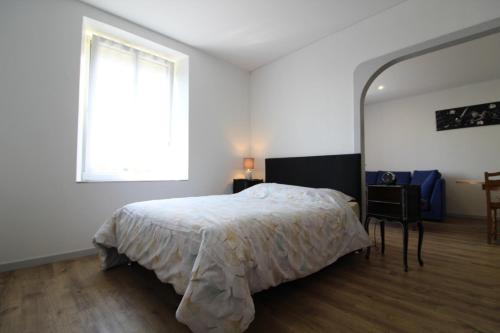 a bedroom with a bed and a window and a chair at Gîte Chez Reine à ÉtivalClairefontaine Vosges Cal in Étival-Clairefontaine