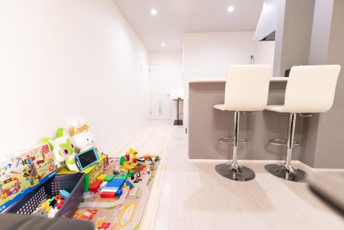 a kitchen with two white stools and a toy store at OPEN SALE! 7 min Osu! New! 1LDK! Family! 1 min Park! in Nagoya