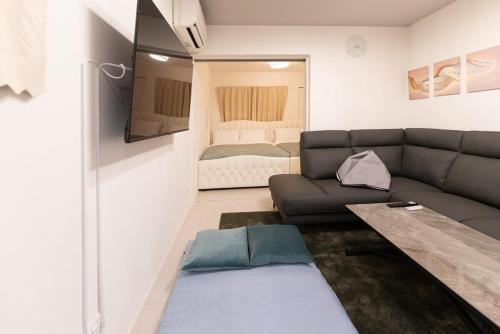 a living room with a couch and a bed at OPEN SALE! 7 min Osu! New! 1LDK! Family! 1 min Park! in Nagoya