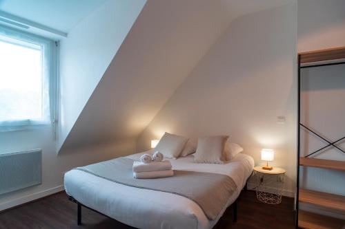 een slaapkamer met een bed met twee handdoeken erop bij Ty Kordenn - Proche Plage in Sarzeau