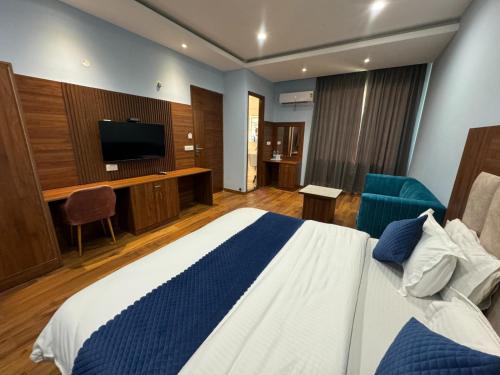 Un dormitorio con una cama y un televisor de pantalla plana. en Hotel Candy Prime, en Chandigarh Airport